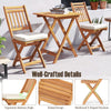 Outdoor wood bistro set featuring two chairs with soft cushions and a folding table, perfect for backyard relaxation.