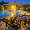 9FT tan patio solar umbrella with LED lights, steel tilt and crank, ideal for outdoor relaxation by the pool.