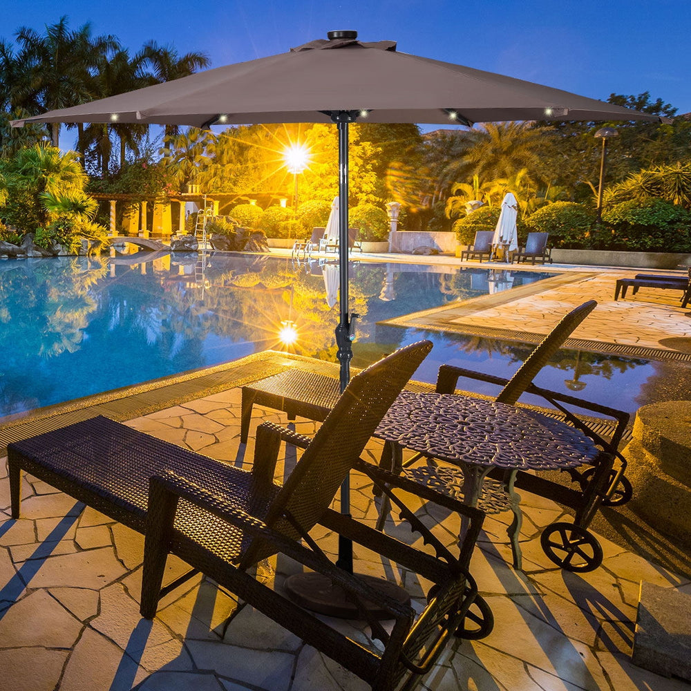 9FT tan patio solar umbrella with LED lights, steel tilt and crank, ideal for outdoor relaxation by the pool.