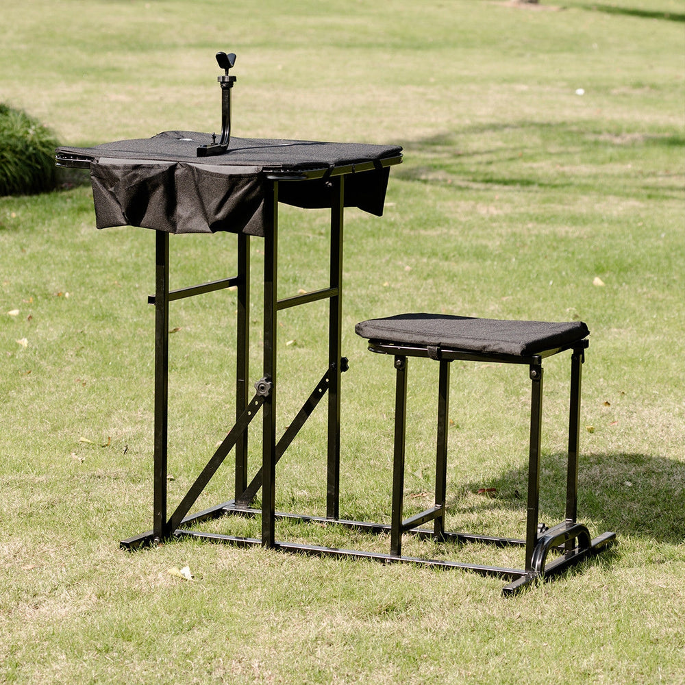 Foldable shooting bench with adjustable height table and stool, designed for outdoor use and target practice.