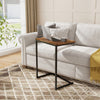 C-shaped industrial end table featuring a spacious tabletop, ideal for work or snacks, fitting snugly beside a sofa.