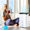 100-pint dehumidifier in white with smart app control, ideal for large rooms up to 5500 sq.ft, shown in a cozy home.