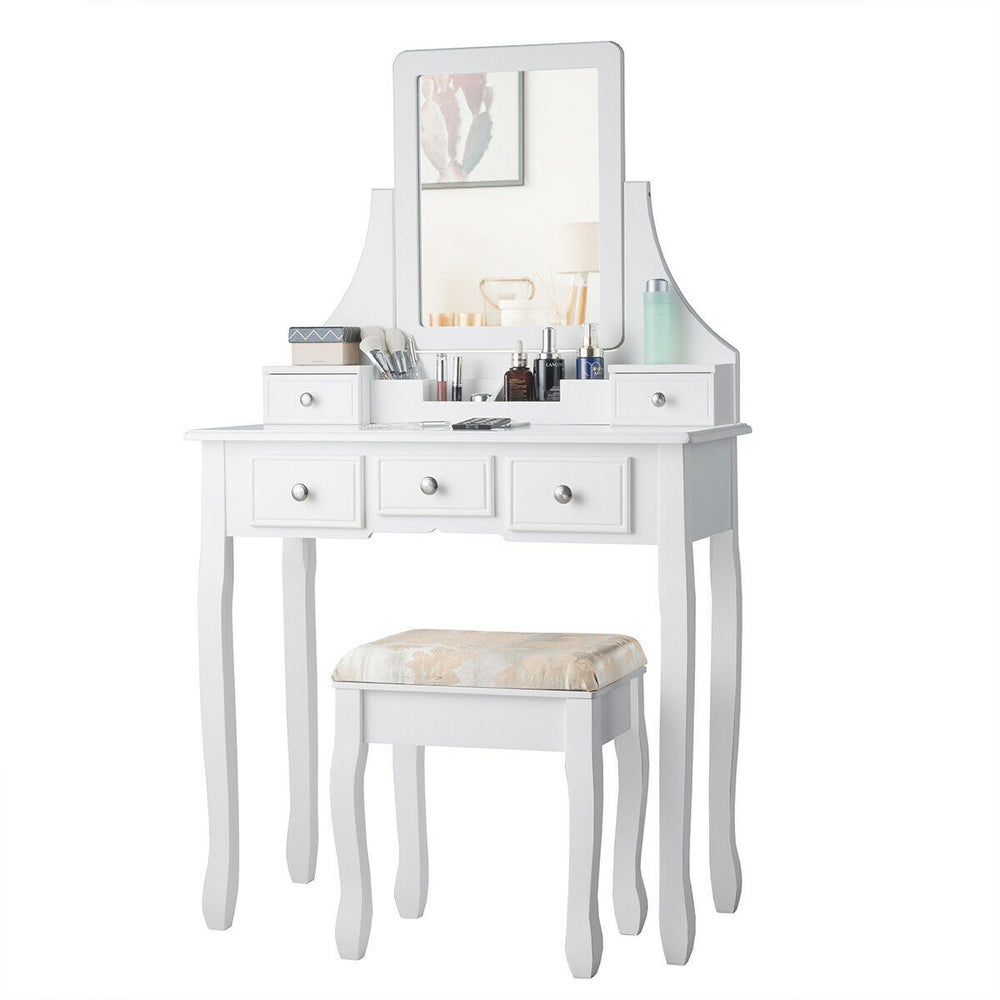White makeup dressing vanity set with 5 drawers, removable top, and padded stool for comfortable use and stylish decor.