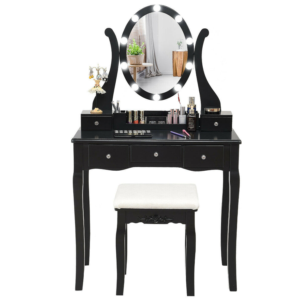 Black vanity table set with lighted mirror, cushioned stool, and 5 drawers for ample storage in any space.