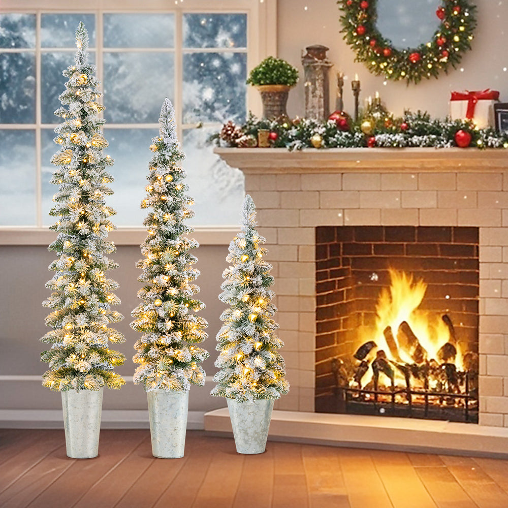 Set of 3 pre-lit snow flocked artificial Christmas trees in metal pots, featuring warm white LED lights for festive.