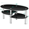 Black oval coffee table with tempered glass top and sleek chrome legs, featuring two shelves for added storage.