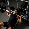 Weight lifting barbell with chrome finish and knurled handles, ideal for bench presses and heavy workouts.