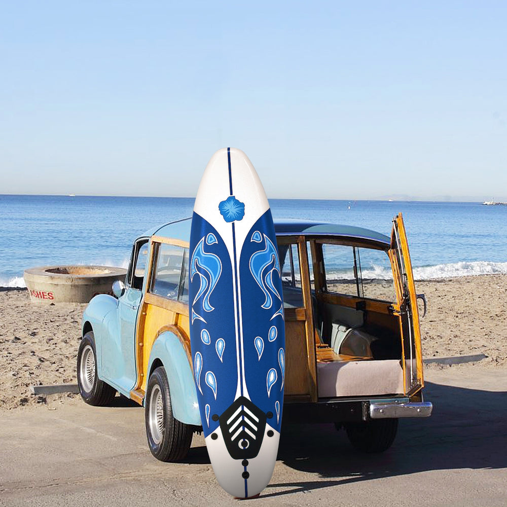 6 feet surfboard with blue design and detachable fins, ideal for beginners, placed on a vintage car at the beach.