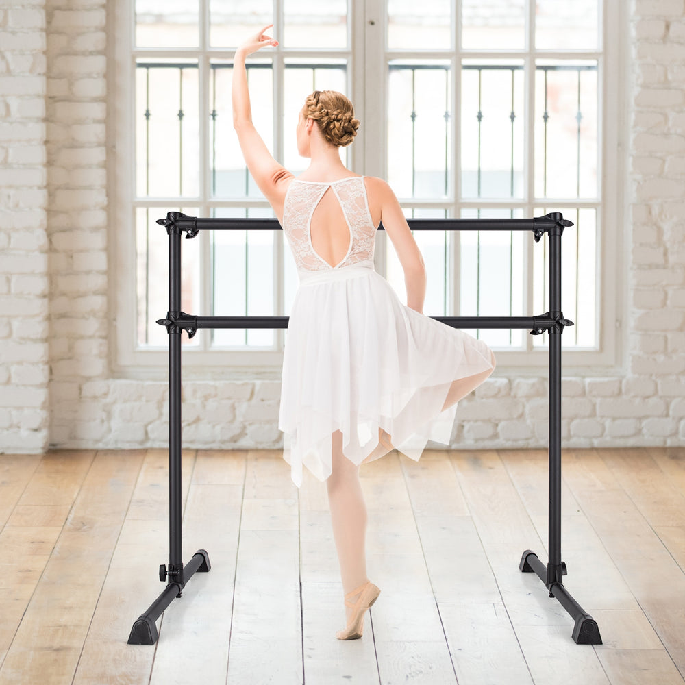 Ballet dancer practicing at a 4 feet adjustable black ballet barre, ideal for stretching and dance exercises.