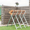 Heavy duty portable foldable steel sawhorse supporting logs, featuring a stable triangular structure for efficient use.