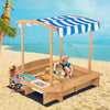 Kids wooden sandbox with striped canopy, made of solid cedar, perfect for outdoor play and relaxation at the beach.