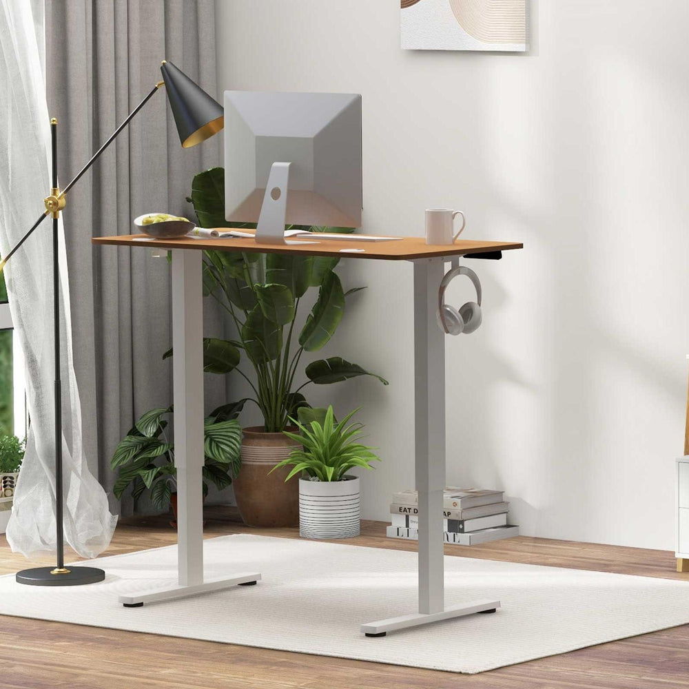 Compact standing desk with electric lift and ergonomic high-back chair, perfect for small home offices.