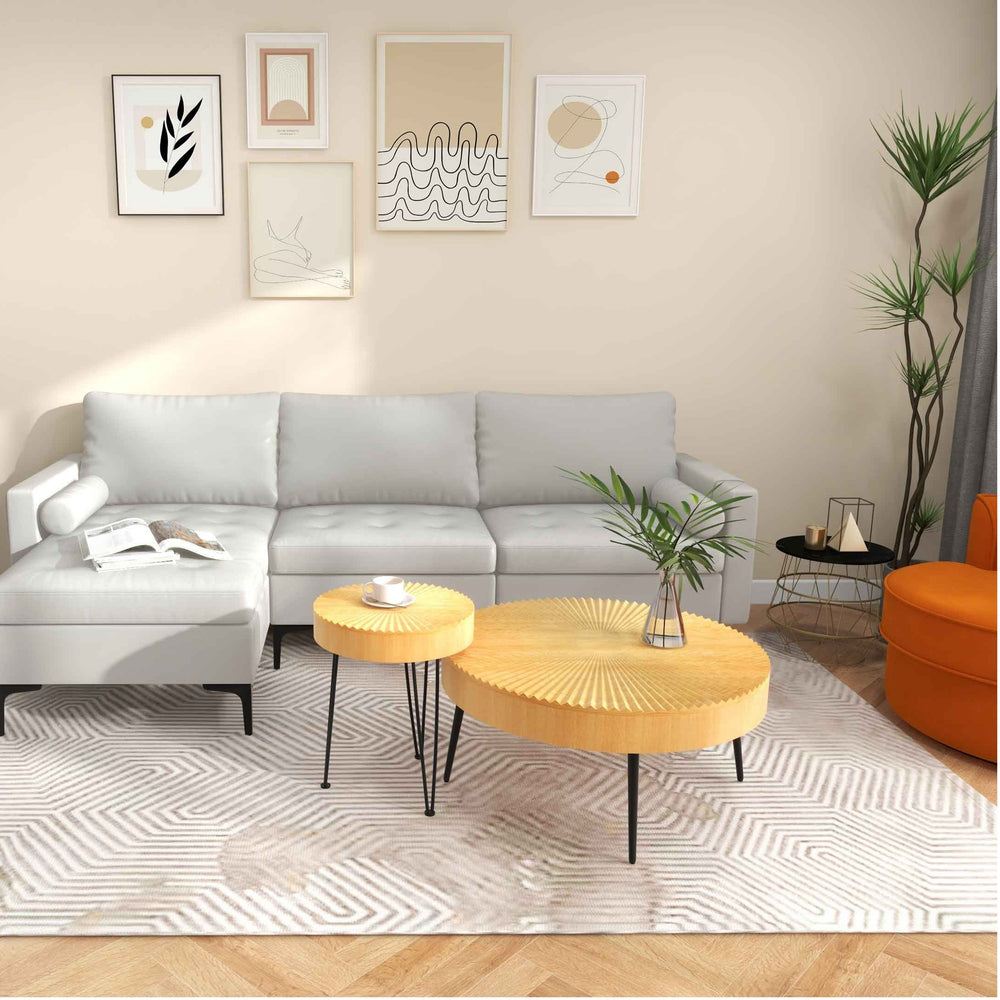 L-shaped modular sofa in grey with round nesting coffee tables and faux marble side table for modern living spaces.