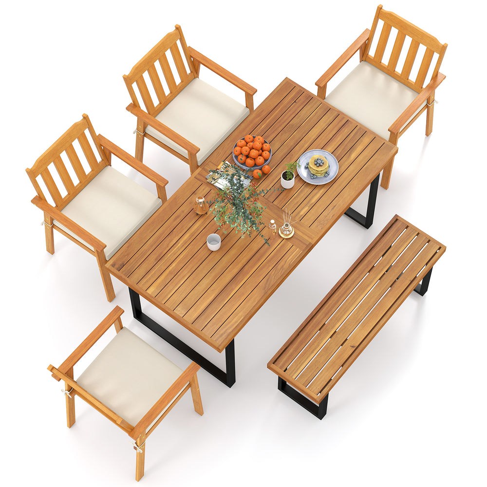 Patio dining set featuring a 63” acacia wood table, four armchairs, and a backless bench for outdoor gatherings.
