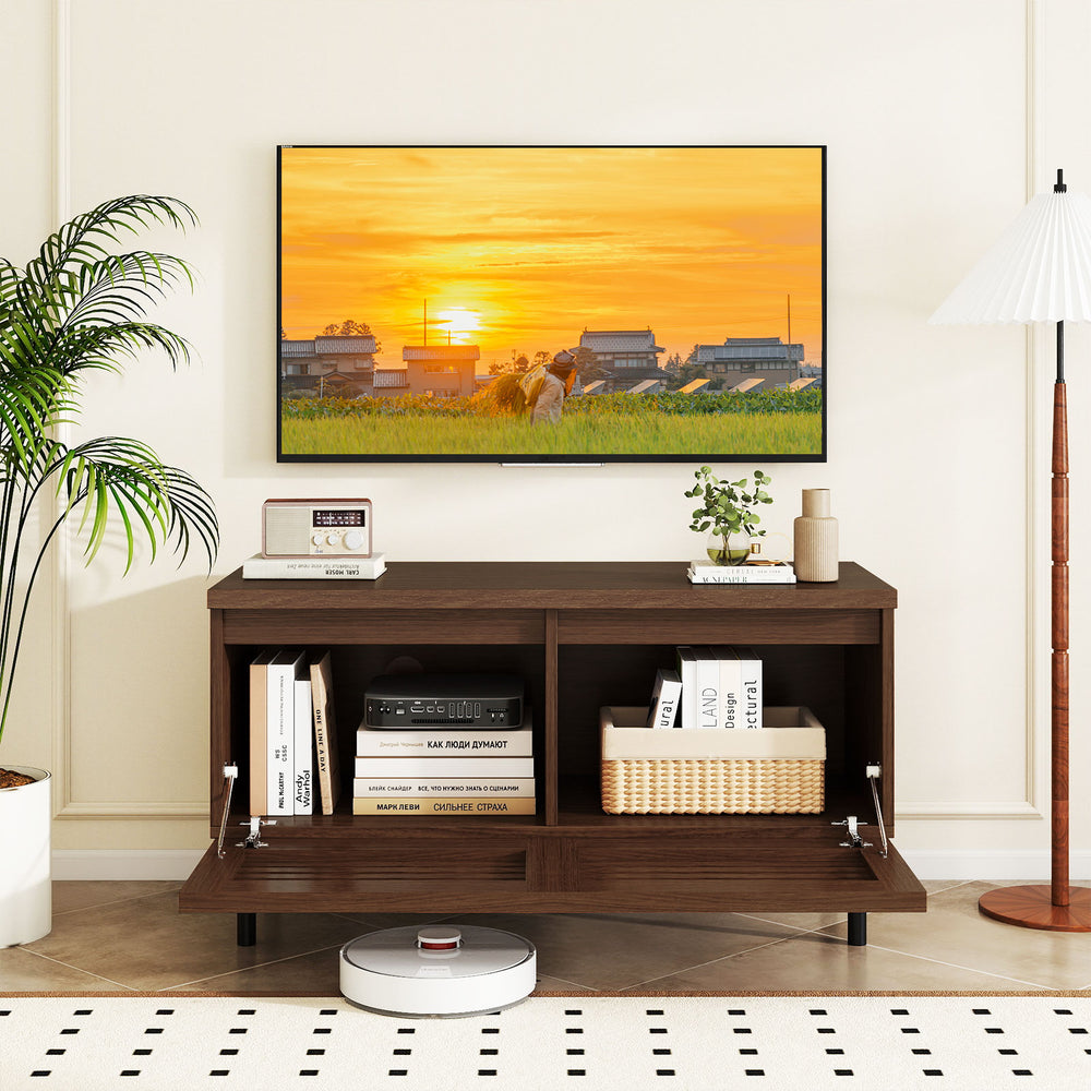 Mid Century fluted TV stand in walnut with metal legs, featuring open compartment and hidden storage for a tidy space.