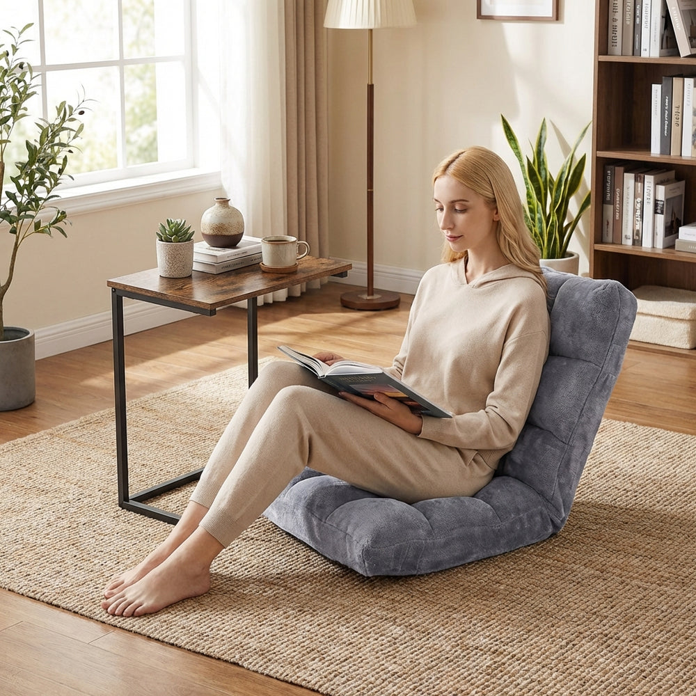 Adjustable floor chair with thick padded cushion and C-shaped end table, perfect for cozy reading or relaxing.