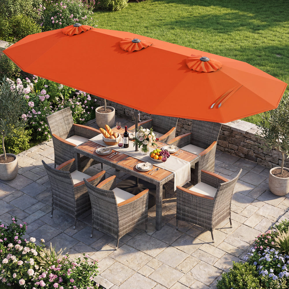 Outdoor wicker dining set with orange double-sided umbrella, featuring ergonomic chairs and acacia wood tabletop for.