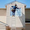 Folding aluminum ladder in use for window cleaning, featuring anti-slip rungs and safe locking hinge for stability.