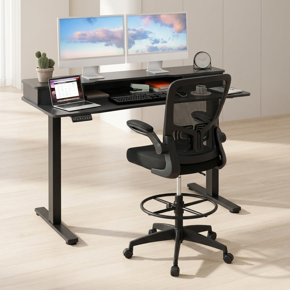 Electric height adjustable standing desk with sleek design and built-in drawers, paired with ergonomic drafting chair.