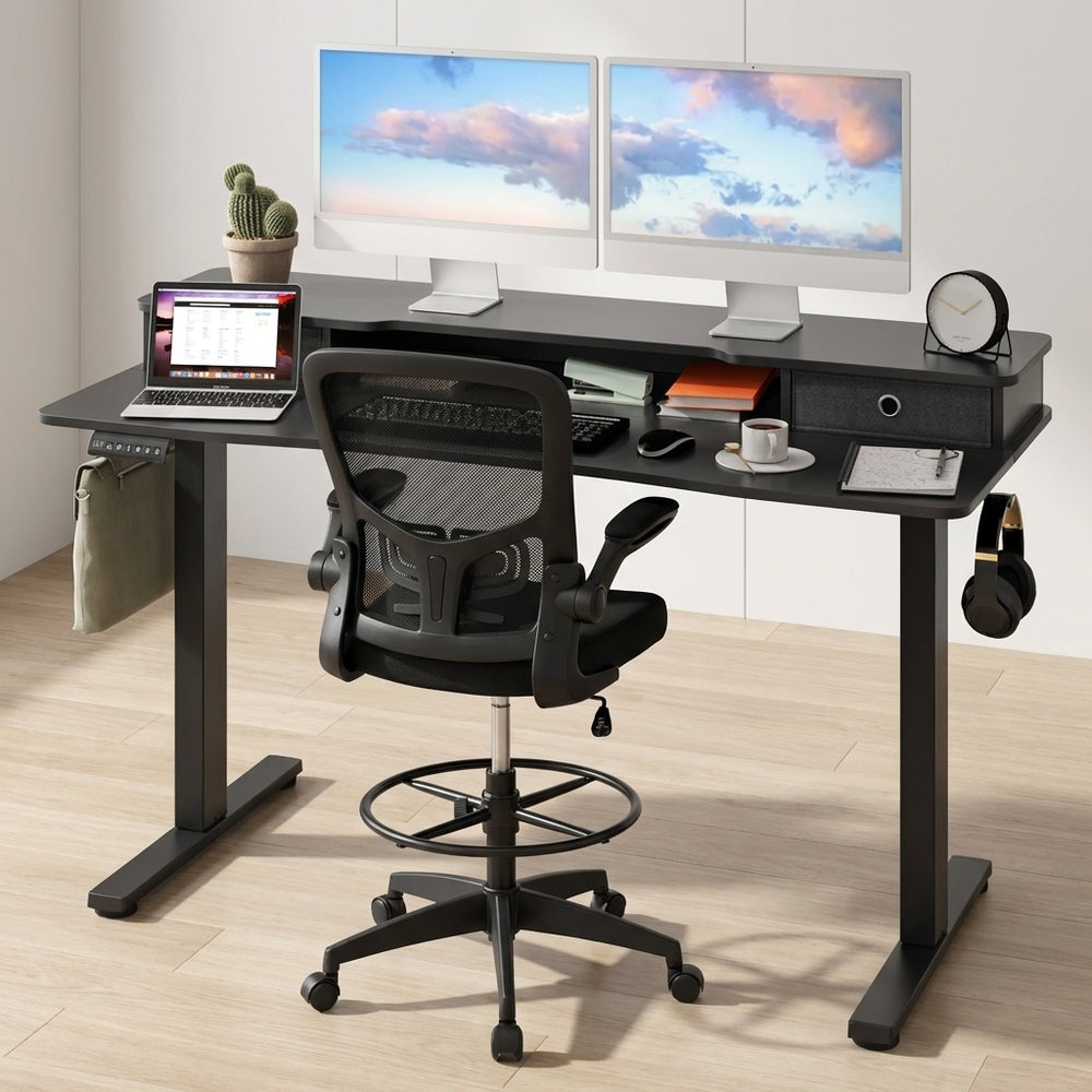 Electric height adjustable standing desk with sleek surface and built-in drawers, paired with an ergonomic drafting.