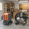 Dehumidifier and industrial drum fan in a workshop, ideal for climate control in garages and large spaces.
