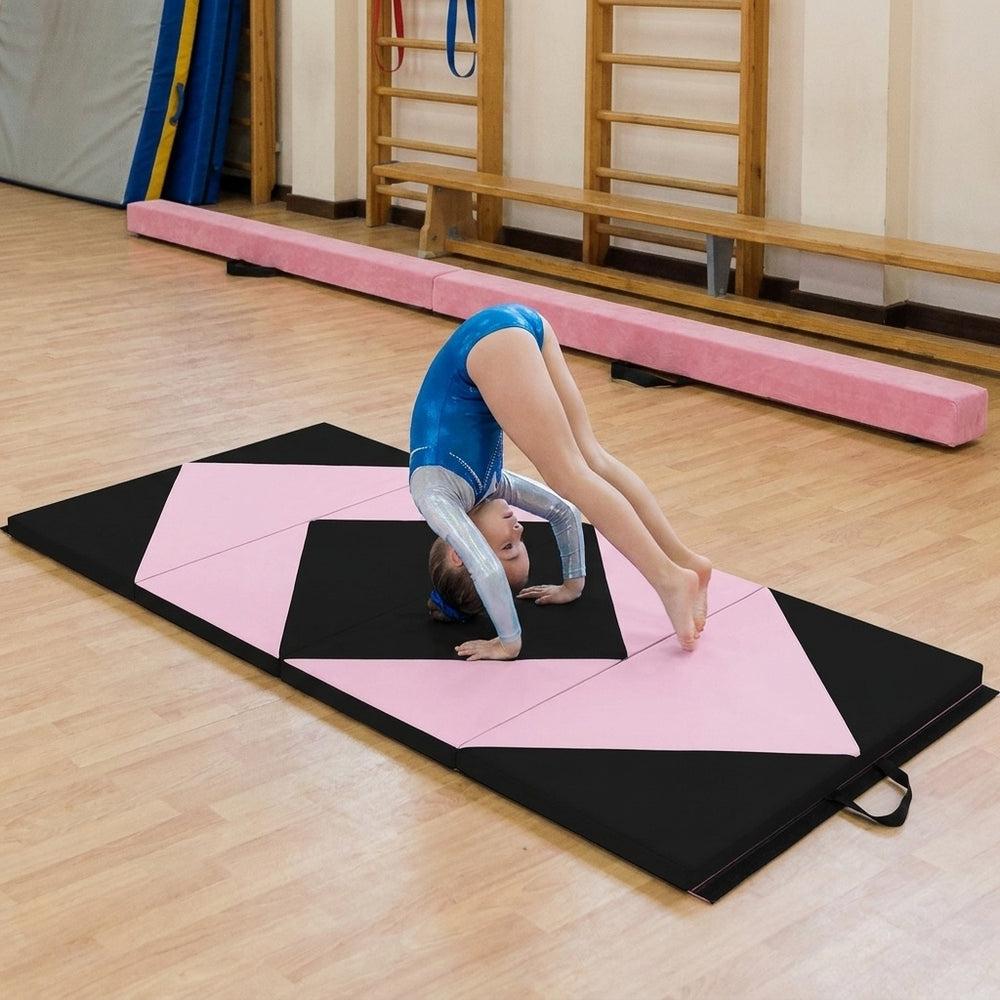 Folding gymnastics mat in black and pink with a gymnast performing a handstand, ideal for training and practice.