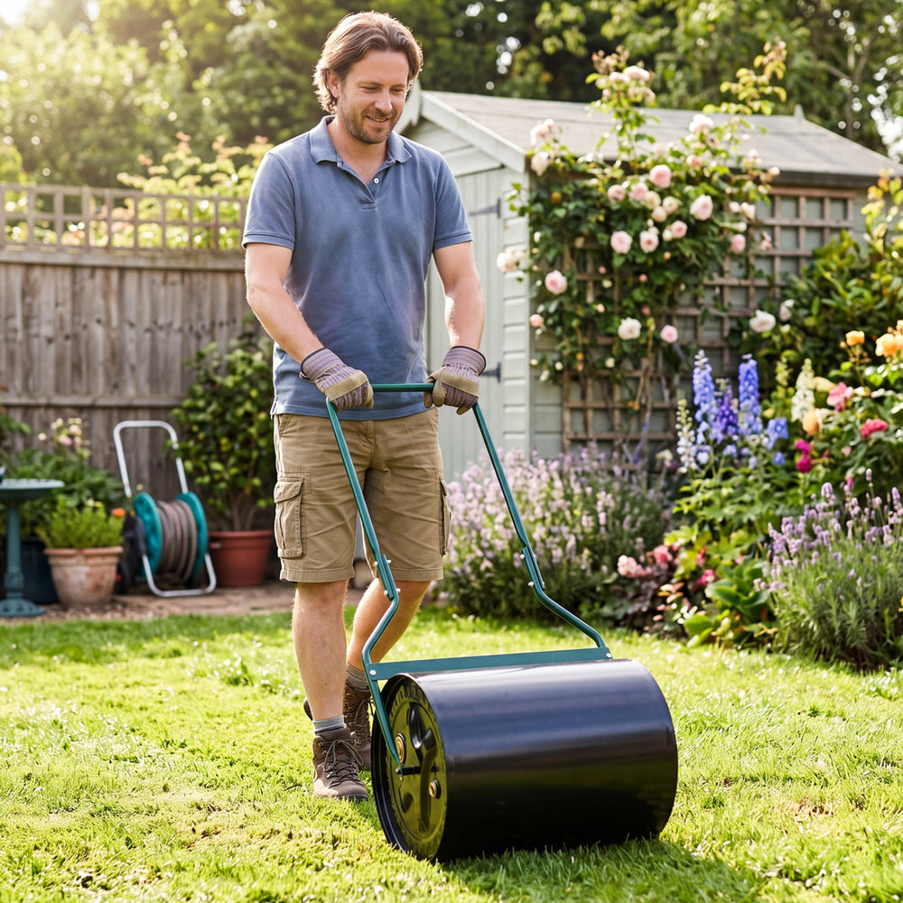 Lawn roller being used in a garden, 12-gallon water/sand filled for effective lawn leveling and maintenance.