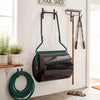 Lawn roller with a 12-gallon capacity, filled with water or sand, hanging in a garden shed for easy storage.