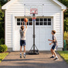 Adjustable portable basketball hoop with shatterproof backboard, shown in use by two players in a driveway setting.