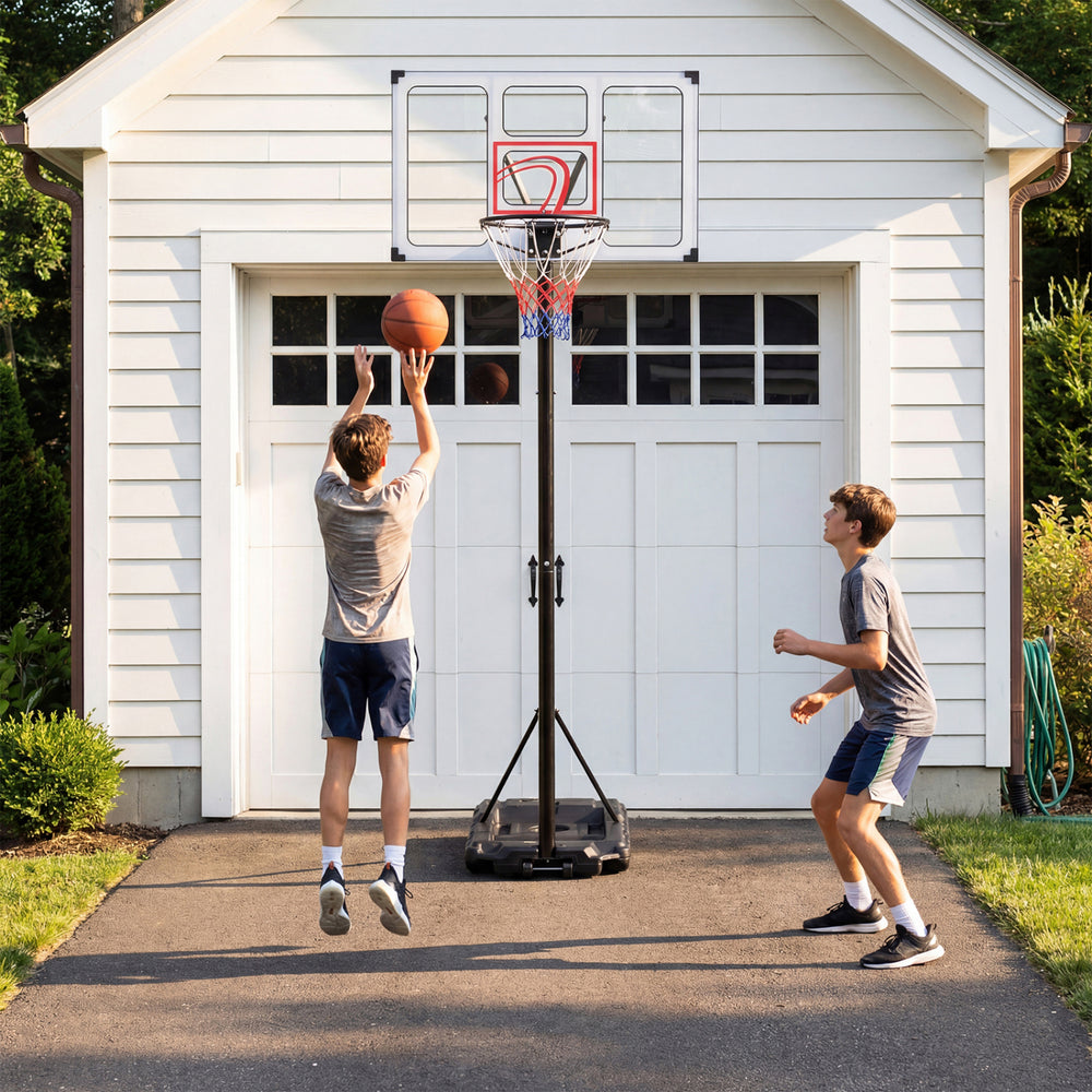 Adjustable portable basketball hoop with shatterproof backboard, shown in use by two players in a driveway setting.