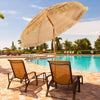 Portable 6.5 feet thatched tiki beach umbrella with adjustable tilt for sun protection by the poolside.