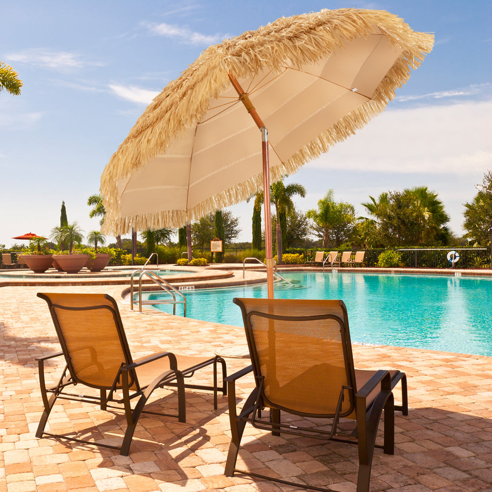 Portable 6.5 feet thatched tiki beach umbrella with adjustable tilt for sun protection by the poolside.