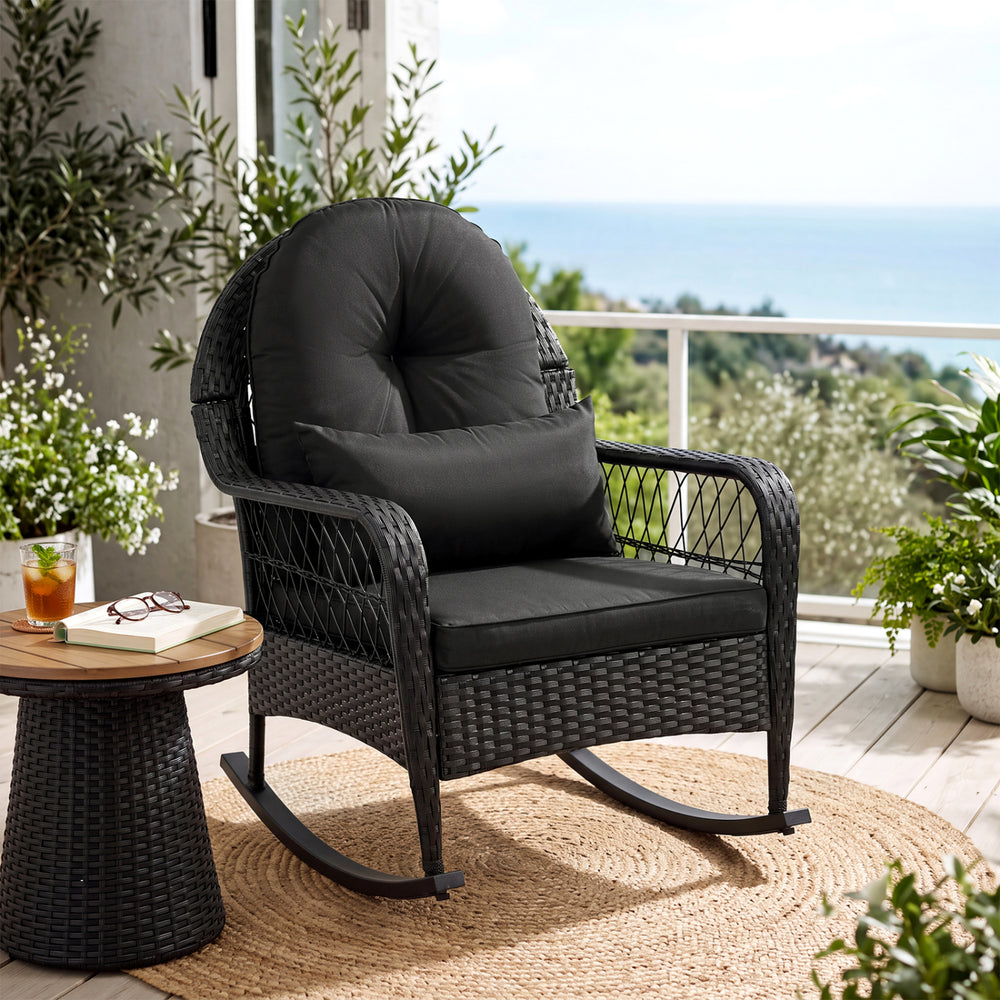 Black outdoor wicker rocking chair with thick cushions, designed for comfort and stability on patios and porches.