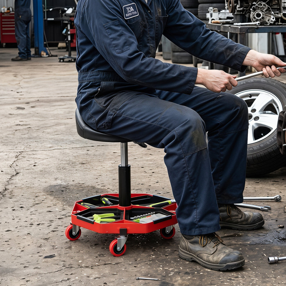 Height adjustable garage seat with a black and red PU leather cushion and detachable storage tray for tools.
