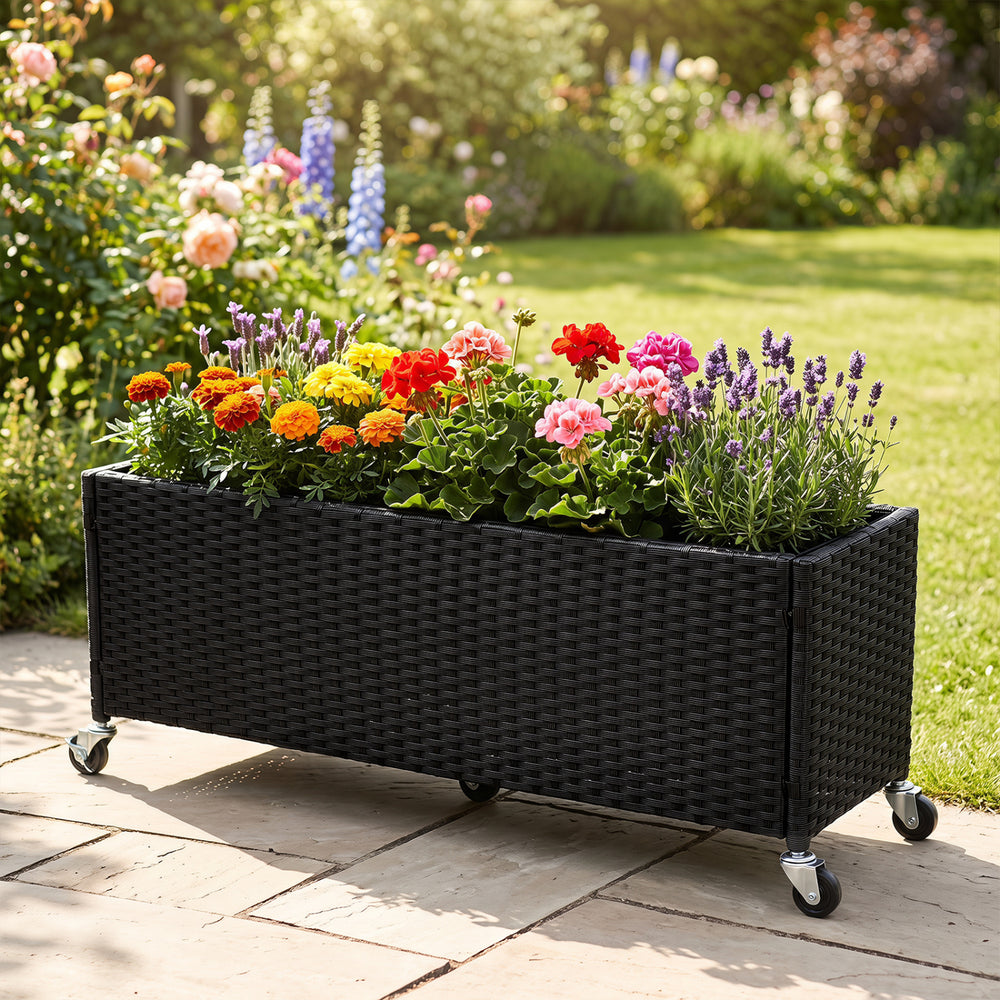 Raised garden bed made of fade-resistant PE rattan with wheels, ideal for displaying flowers and plants in outdoor spaces.