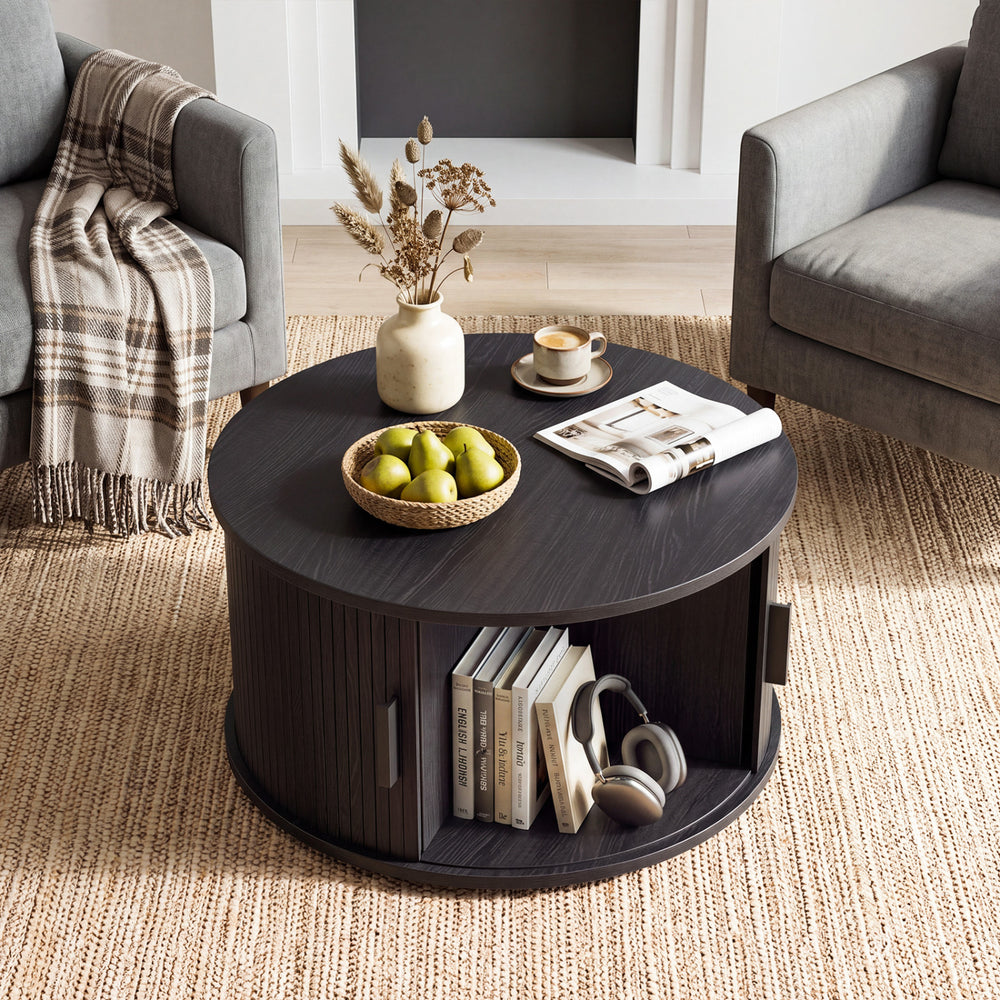 Round black coffee table showcasing a spacious tabletop and sliding tambour door for stylish and practical living room storage.