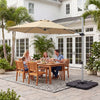 Beige 11 ft cantilever patio umbrella shown open over a dining set, anchored by a heavy-duty 4-piece base.