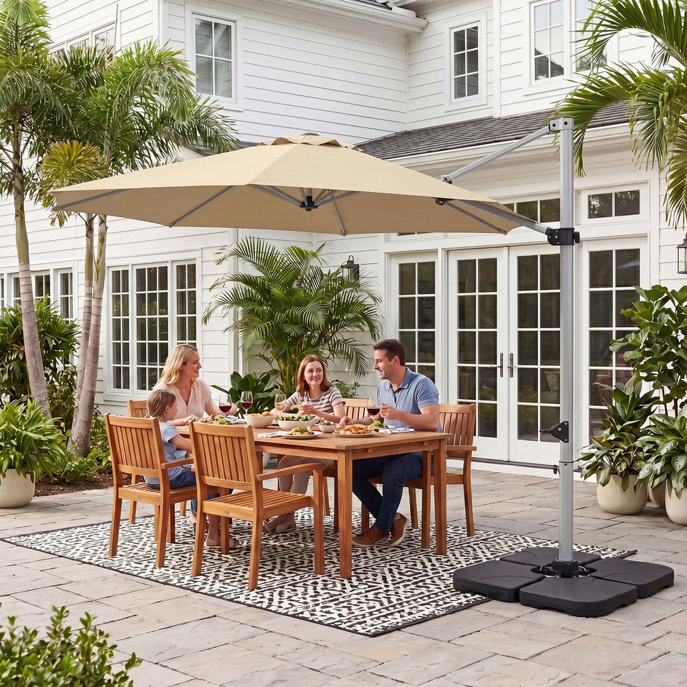 Beige 11 ft cantilever patio umbrella shown open over a dining set, anchored by a heavy-duty 4-piece base.