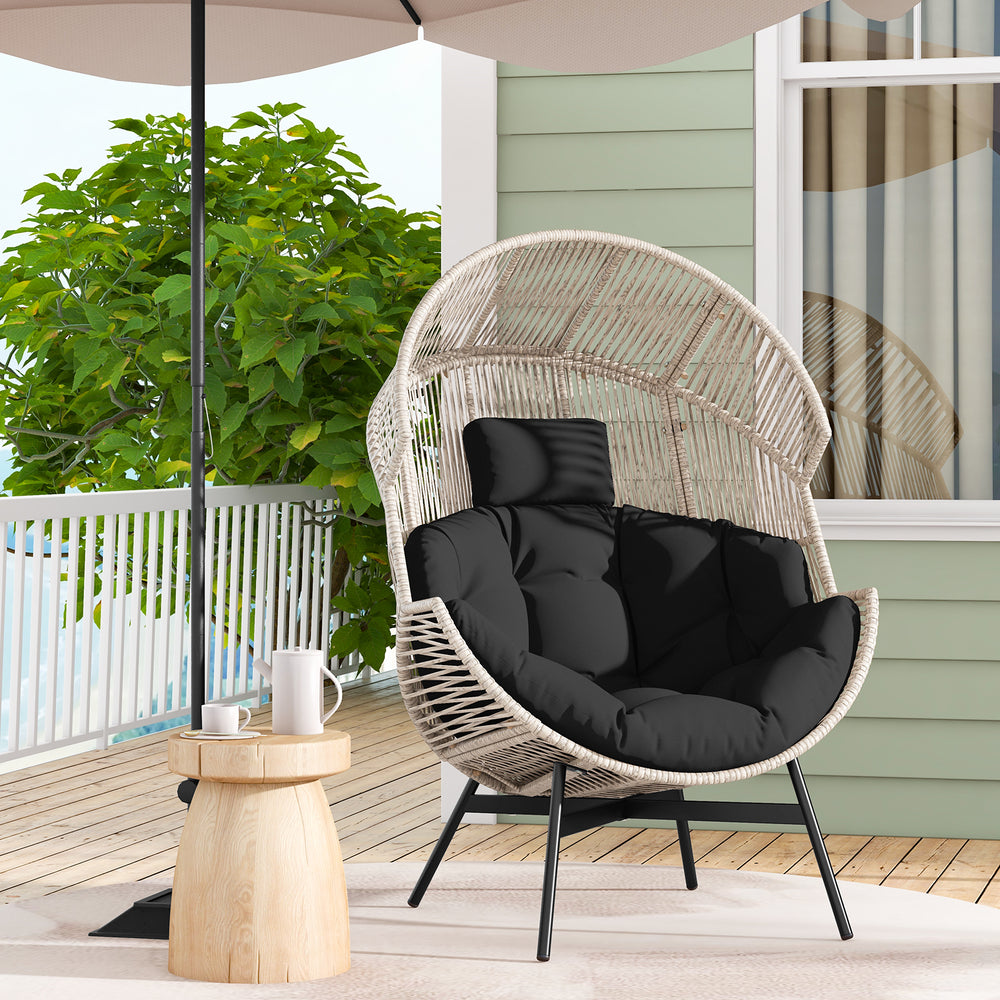 Oversized wicker egg chair with black cushions and headrest, perfect for backyard or poolside relaxation.