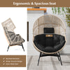 Wicker oversized egg chair with ergonomic backrest, black cushions, and headrest for spacious relaxation in any setting.