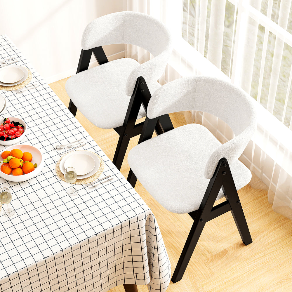 Mid-century modern dining chairs in white faux sherpa with black wood frames, perfect for stylish kitchen dining.