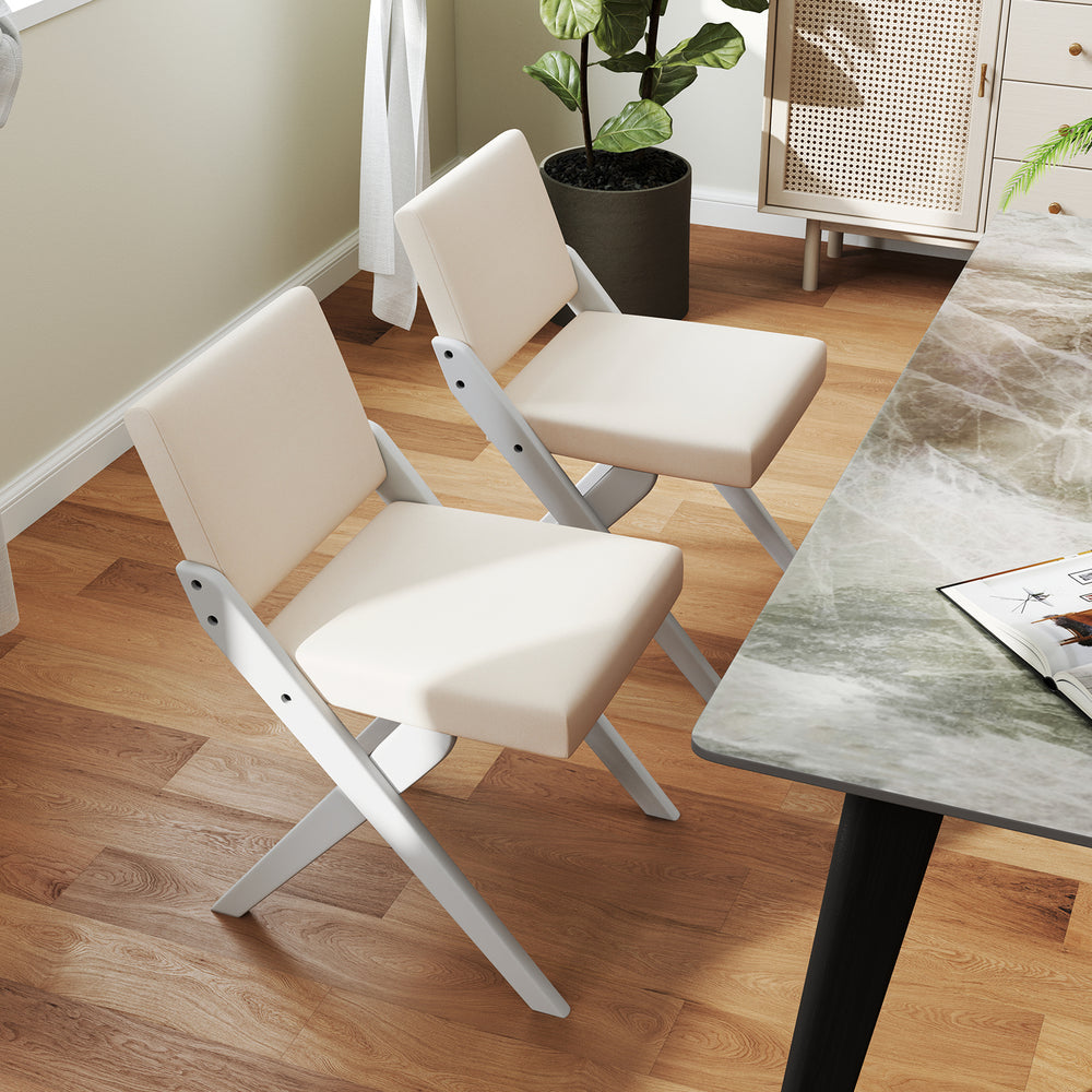 Two wooden dining chairs with white padded cushions and rubber wood frames, perfect for modern farmhouse dining areas.