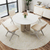 Round dining table with four white padded chairs, featuring rubber wood frames for modern farmhouse aesthetics.